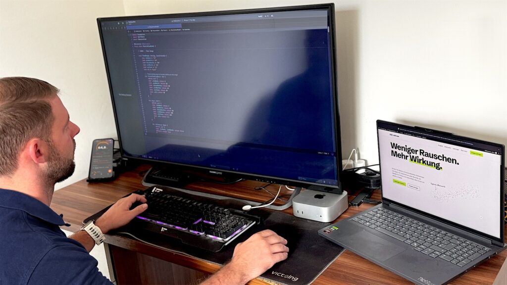 Tim Remus am Schreibtisch: auf dem großen Monitor Code in Xcode, links das iPhone mit BodyLytics, rechts ein Laptop mit liftcode.de
